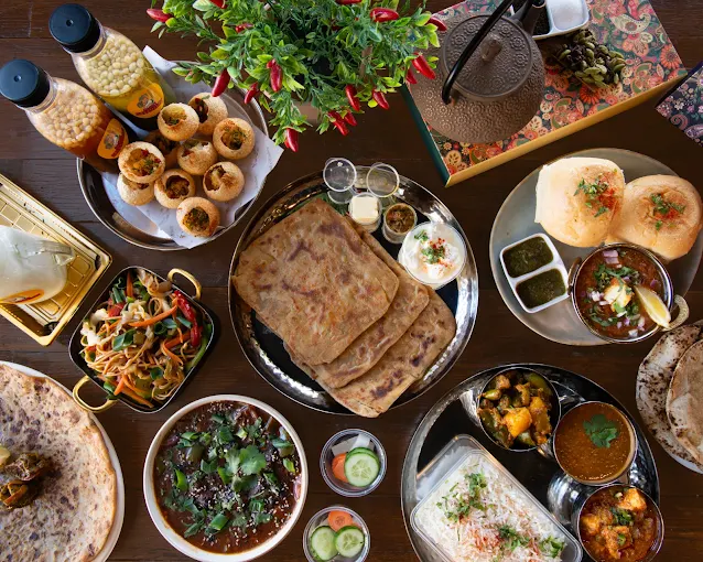 Daadi's Kitchen Parramatta a wide table spread of Indian dishes including parathas, chaat and curries