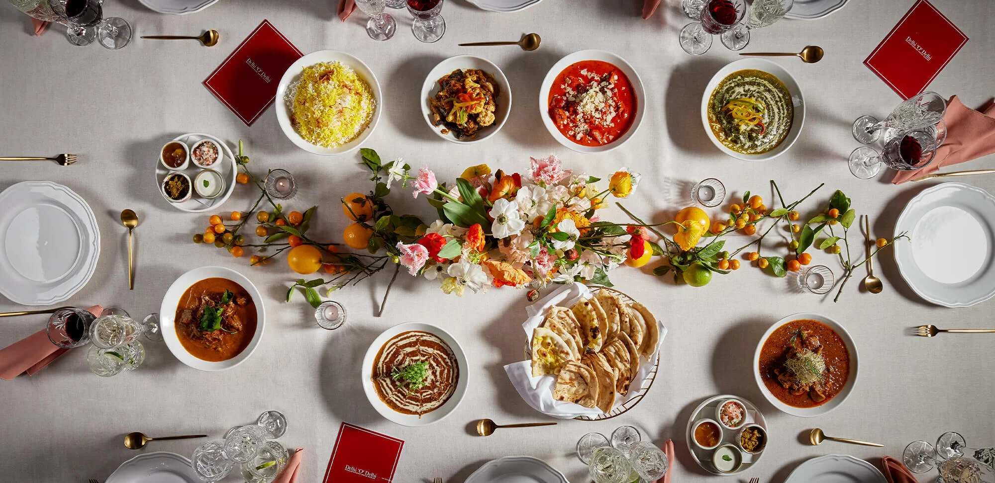 Delhi O Delhi elegant plated catering table setting with curries, naan and flowers in Sydney