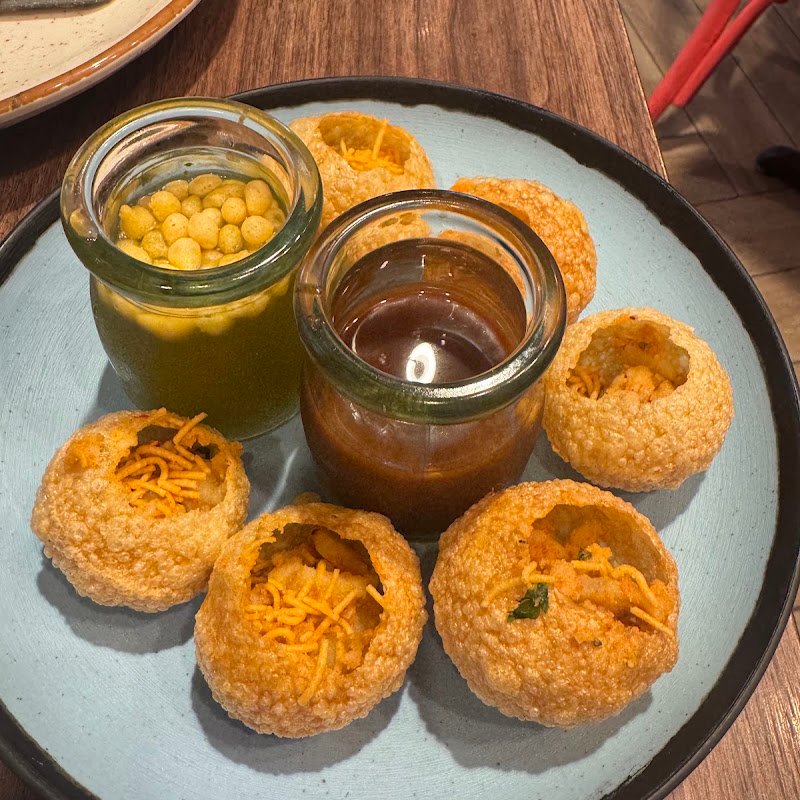 Masala Kitchen World Square pani puri served with tamarind and mint water in glass jars