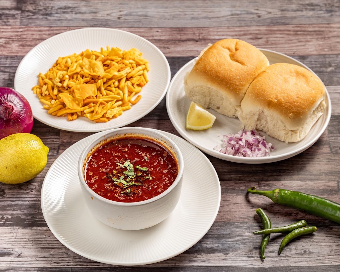 Mumbaicha Vadapav Parramatta misal pav bowl with farsan alongside pav rolls onion and lemon