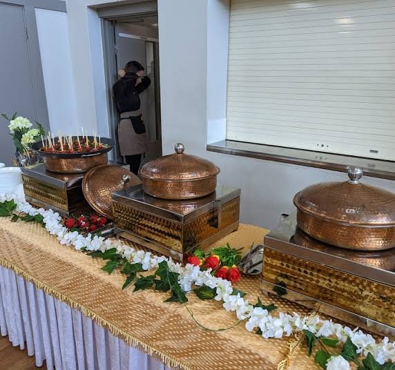Nirvana Catering and Events copper chafing dishes decorated with flowers at a Sydney function