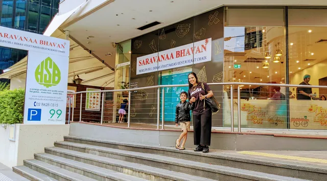 Saravanaa Bhavan Parramatta storefront entrance with a parent and child