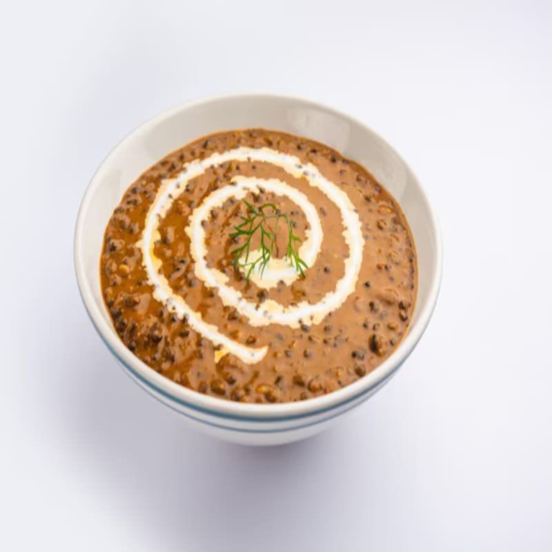 Simply Indian Harris Park dal makhani with cream swirl in a white bowl